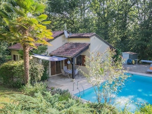 A house with a swimming pool, surrounded by lush greenery and a patio area with outdoor seating. - Garden Home with Ensuite (Saint Martin le Redon)