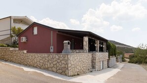 Un bâtiment doté d’une façade en pierre, d’une couleur rouge et d’un porche abrité.