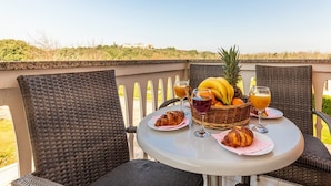 A round table with wicker chairs on a balcony overlooking a landscape. - Banjole Fun & Family Stay (Banjole)