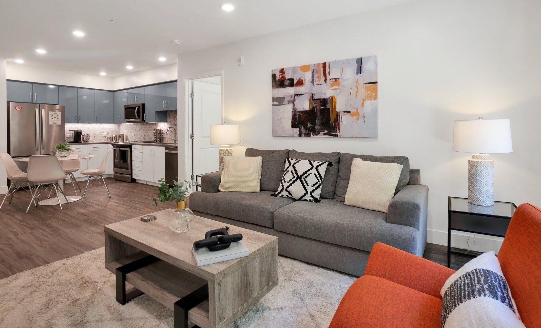 A modern apartment with a living room, dining area, and kitchen.