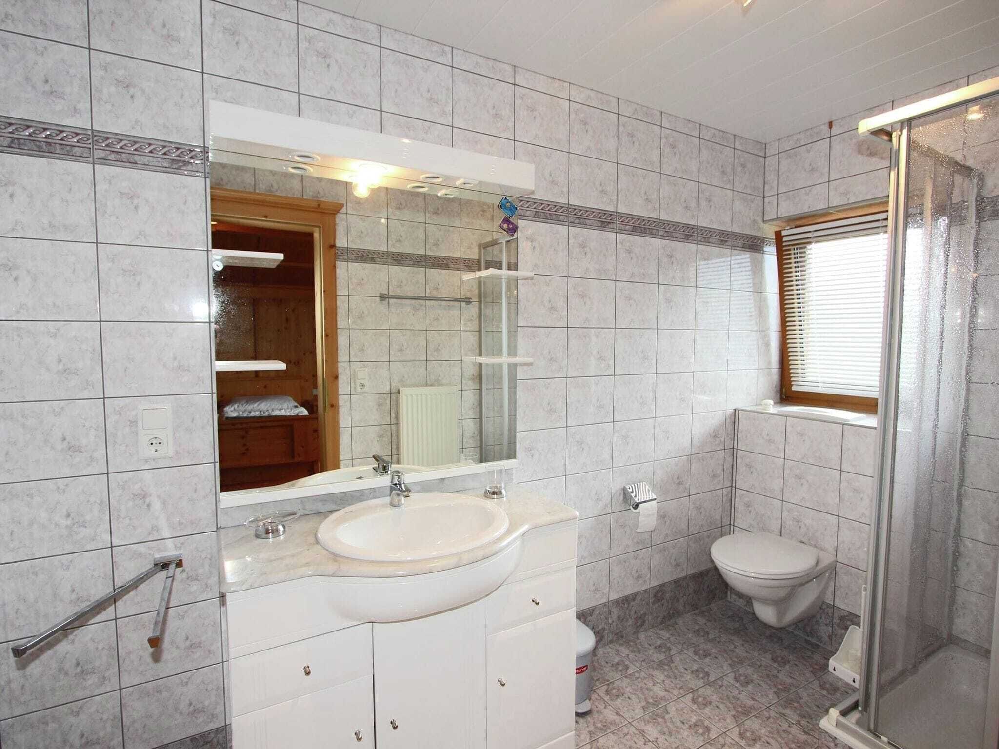 Ein Badezimmer mit Waschbecken, Spiegel, Toilette und Dusche.