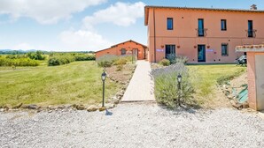 A building with a gravel driveway leading to a wooden pathway.