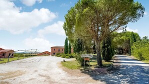 A rural driveway leading to a building with a sign reading "Agriturismo."