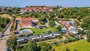 An aerial view of a residential area with a mix of single-family homes and apartment buildings, a swimming pool, and a well-maintained green space. - Banjole Cozy Family Retreat (Banjole)