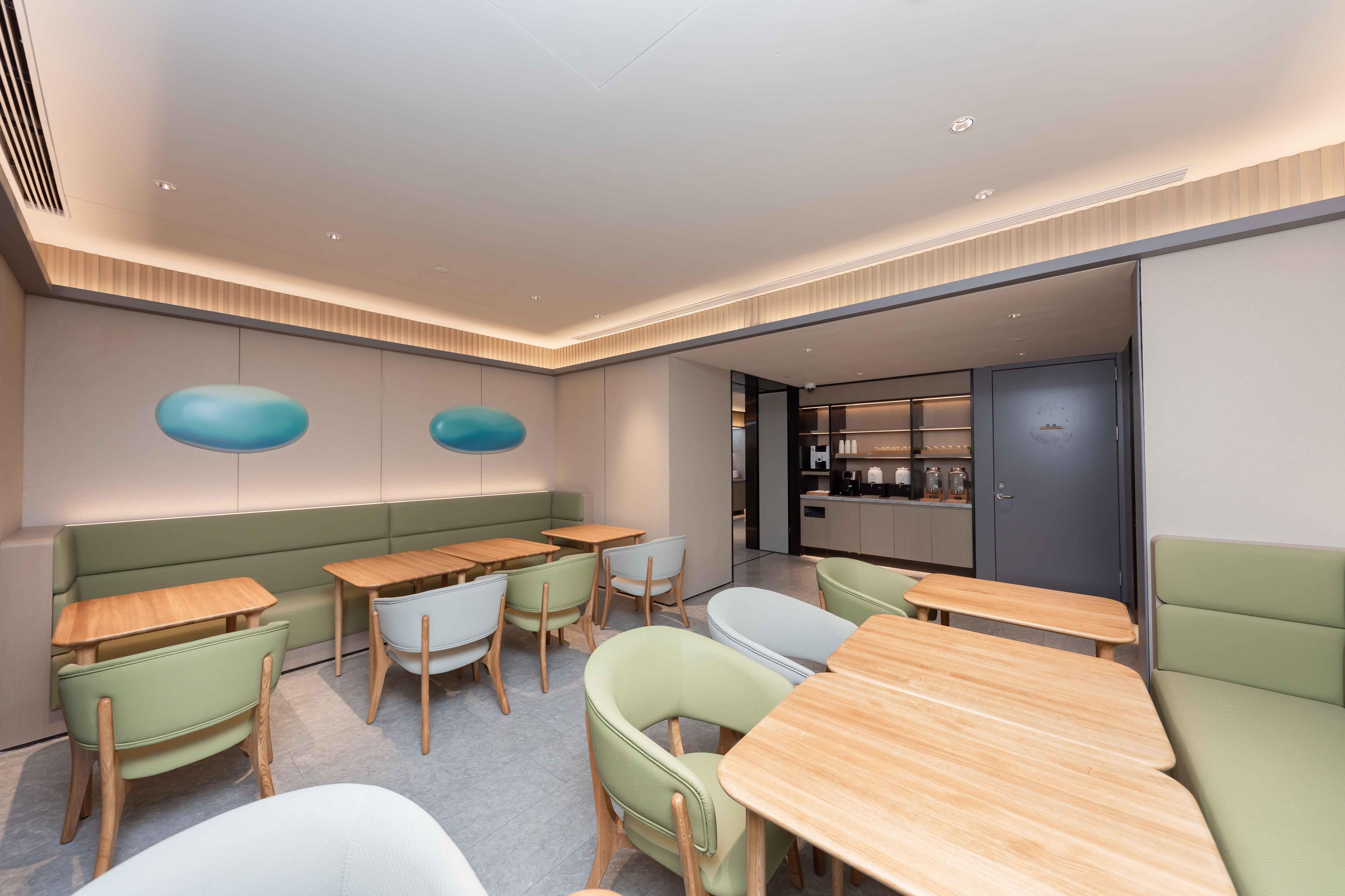 A modern interior with seating arrangements, a kitchen area, and a visible door.