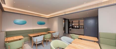 A modern interior with seating arrangements, a kitchen area, and a visible door.
