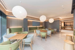 A modern interior with seating areas, tables, and pendant lighting.