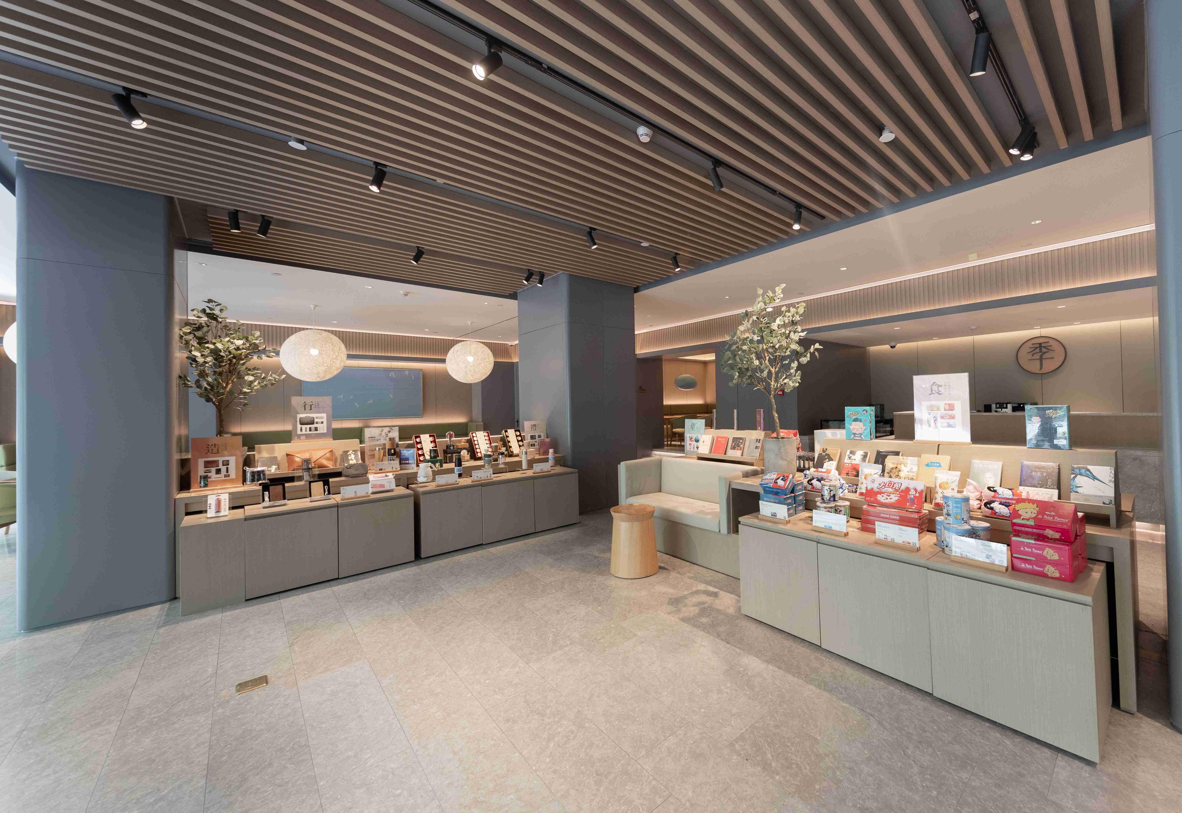 Una moderna zona de recepción con mostrador, asientos y plantas decorativas.