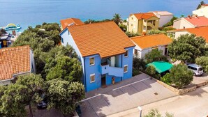 A coastal residential area with houses featuring red-tiled roofs and a blue building with a balcony. - Mandre Coastal Hideaway (Mandre)