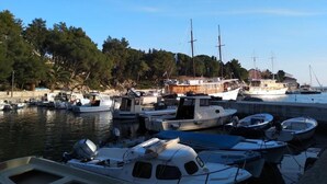 A marina with various boats docked, surrounded by trees and buildings. - Mandre Coastal Hideaway (Mandre)