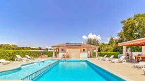 A swimming pool with lounge chairs, a barbecue area, and a small building with a tiled roof. - Mobile Home in Banjole near Beach (Banjole)