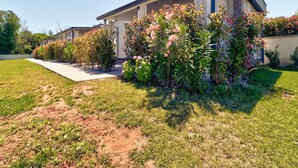 A modern two-story house with a covered porch, surrounded by well-maintained gardens and a clear sky. - Mobile Home in Banjole near Beach (Banjole)