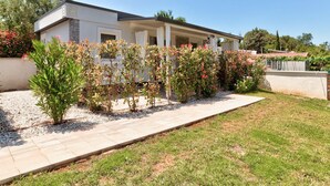 A modern two-story house with a covered patio, surrounded by well-maintained gardens and a gravel pathway. - Mobile Home in Banjole near Beach (Banjole)