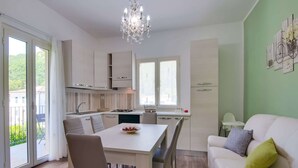Una cucina moderna con mobili bianchi, un tavolo da pranzo e un lampadario.