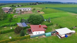 A rural property with multiple buildings, including a large barn, a white house with a red roof, and various outbuildings. - Cozy Baltic Escape for 2 Guests (Bastorf / Kägsdorf)