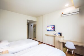 A hotel room with two beds, a desk with a chair, a TV mounted on the wall, and an air conditioning unit. - Hanting Hotel (Hangzhou)