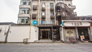 A multi-story building with a modern facade, featuring balconies and a prominent entrance.
