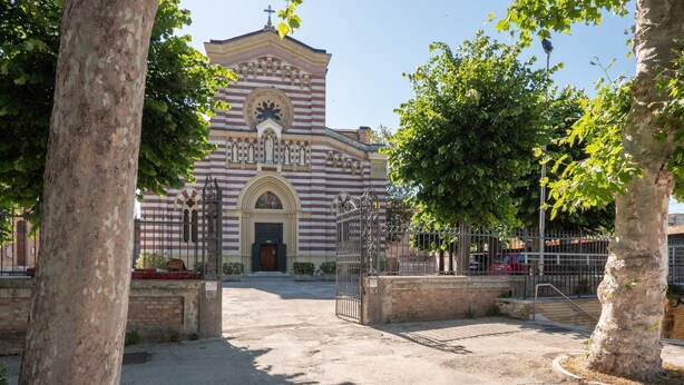 Une église dotée d’une grande entrée en arc de cercle et d’un clocher.