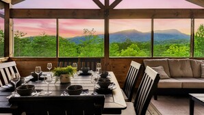 Un coin repas en bois, avec une table dressée pour quatre personnes, donnant sur un paysage montagneux.