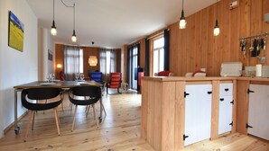 Une cuisine moderne avec des meubles en bois, un îlot central et des luminaires suspendus.