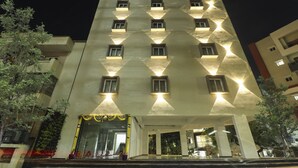 A multi-story hotel with a symmetrical facade, evenly spaced windows, and a central entrance with a decorative arch. - Treebo Sriz Cozy Seethamadhara (Visakhapatnam)