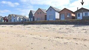 A row of beach houses with a sandy beach in front. - Beautiful holiday home with courtyard (Ravenoville-Plage)