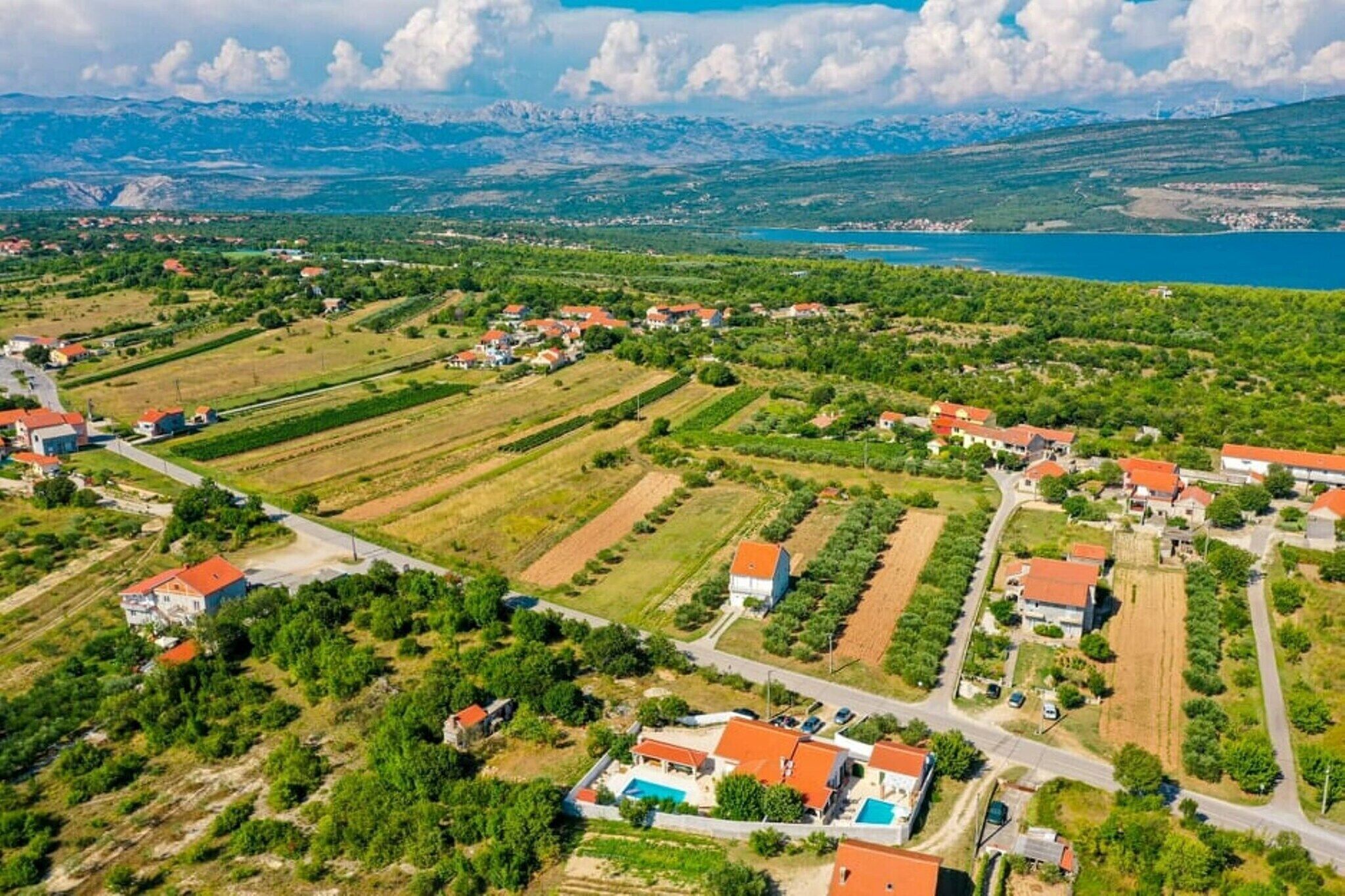 Vista aérea de una zona rural con casas, campos y un lago.