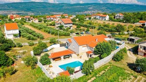 Zona residencial con casas, piscina y montañas al fondo.