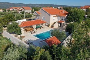 A residential property with a swimming pool, a covered patio, and a view of surrounding houses. - Villa in Pridraga with Private Pool (Pridraga)