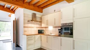 Una cocina moderna con armarios blancos, horno integrado y microondas.