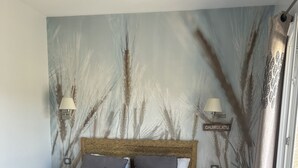 A bedroom with a large bed, two bedside tables, a nightstand, a wall-mounted lamp, a bookshelf, and a curtain. - Villa with pool, between olive trees and sea - fantastic view! (Cargèse)