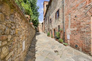 A narrow stone-paved alley flanked by historic buildings with brick walls and small windows. - Varna Charm: Tuscan Getaway (Varna - Gambassi Terme-Fi)