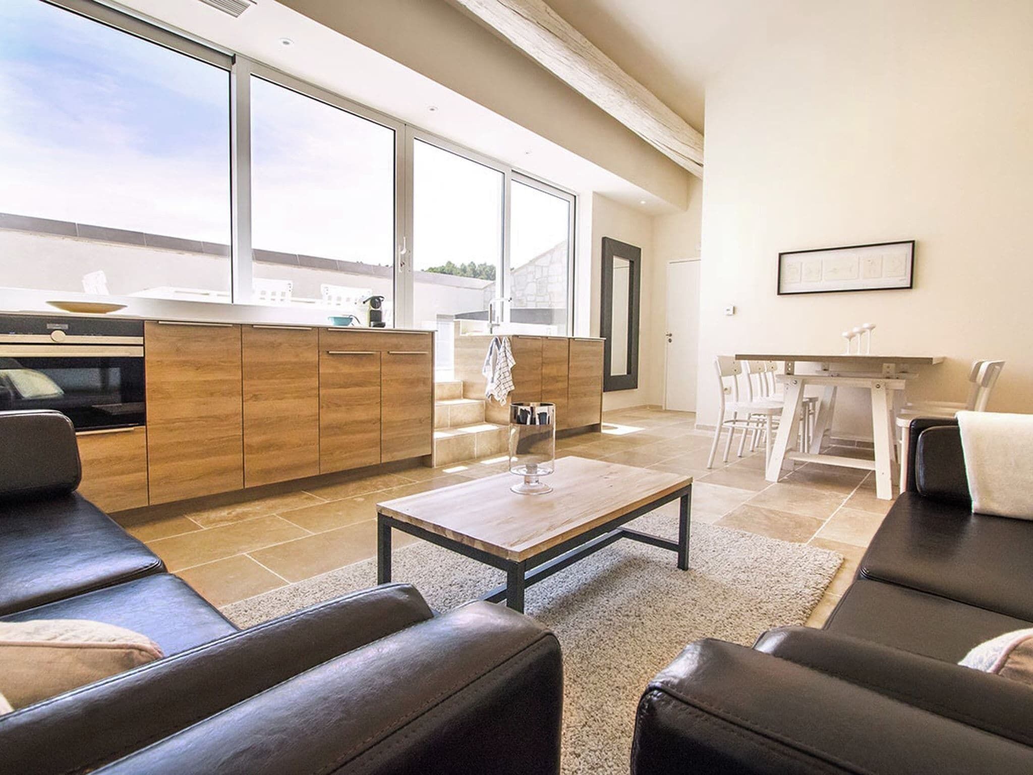 A modern living room with a sofa, a coffee table, and a dining area with chairs and a table.