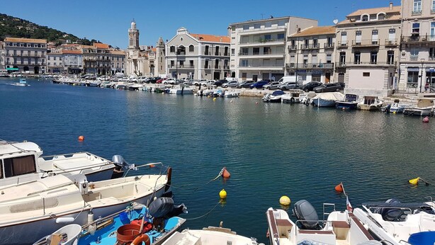 A marina with boats docked, buildings along the waterfront, and a clear blue sky. - Blissful Stay in Mandourelle (Villesèque-des-Corbières)