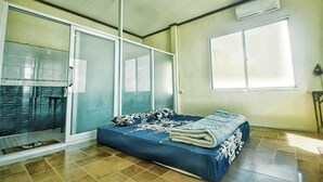 A bedroom with a bed, sliding glass doors, a window, and a ceiling fan. - XALAKHAM PHOUKHOUN - Campsite (Phou Khoun)