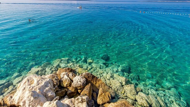 Vista despejada de una costa rocosa con aguas tranquilas y un horizonte lejano.