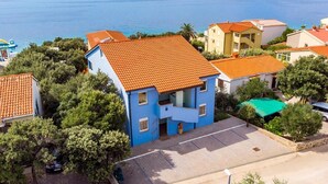 Zona residencial costera con casas de tejas rojas y un edificio azul con balcón.