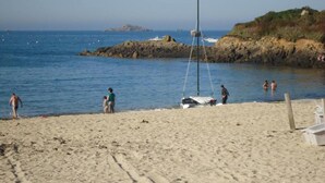 A sandy beach with a sailboat anchored near the shore. - Riviera Hideaway for 2 Guests (La Roquette-sur-Siagne)