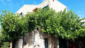 Un edificio de piedra con aspecto rústico, que presenta una puerta y unas escaleras que llevan a ella.