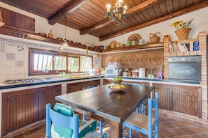 Une cuisine rustique avec des meubles en bois, un îlot central et un four en briques.
