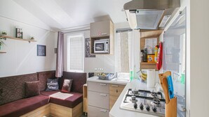 A compact living space with a kitchenette, a sofa, and a dining area.