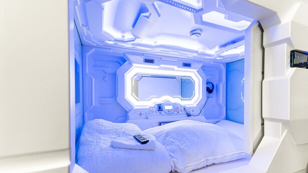 Una habitación futurista con una cama, un panel de control y un ventanal.