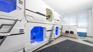 Una sala de diagnóstico por imágenes con dos máquinas grandes, identificadas con los números 01 y 02, un banco con bolsos y una ventana con vista a árboles.