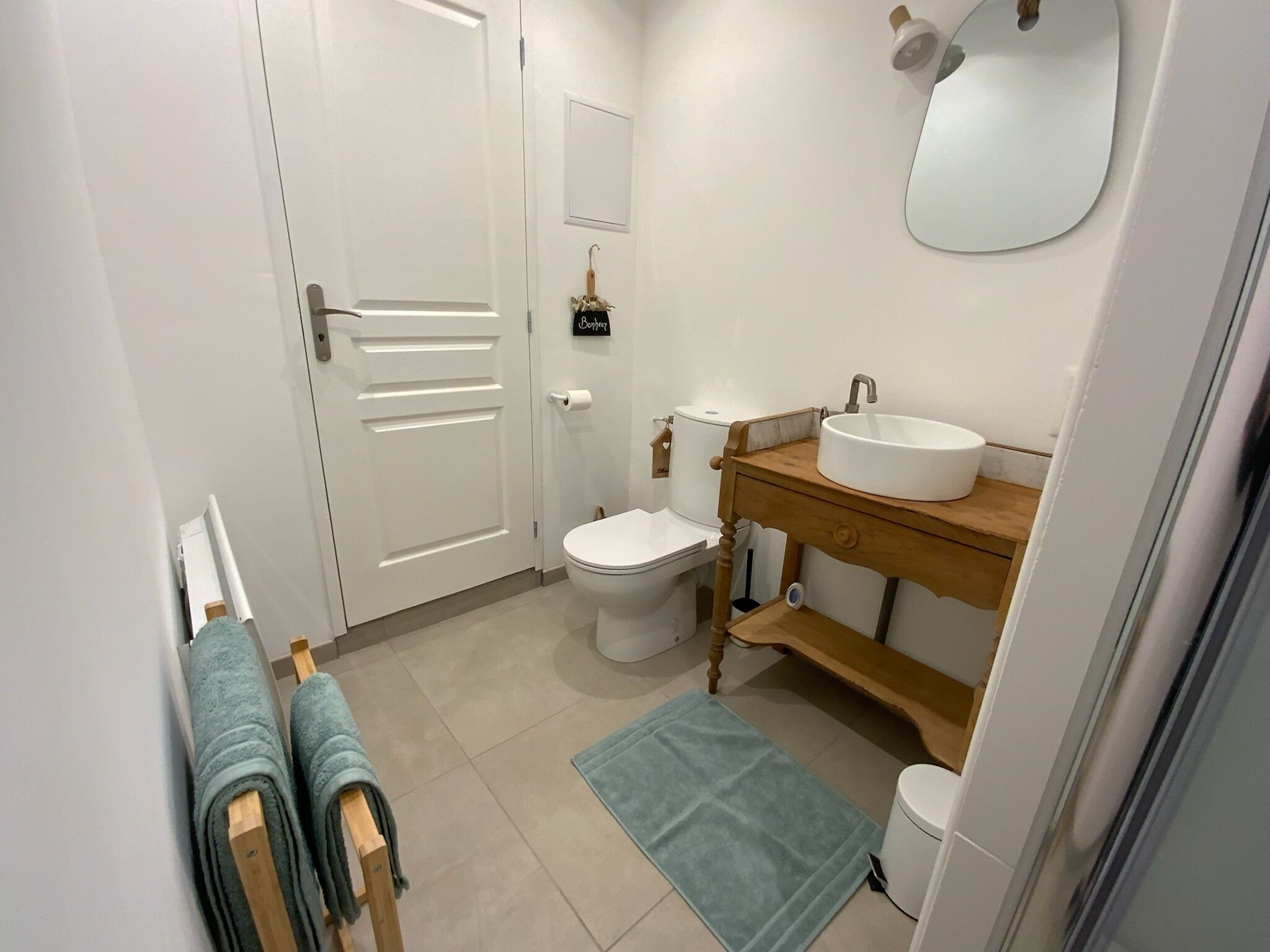 A bathroom with a toilet, sink, and towel rack.