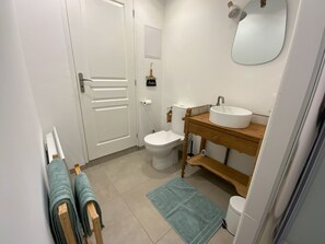 A bathroom with a toilet, sink, and towel rack. - Gîte with private Jacuzzi (St martin choquel)