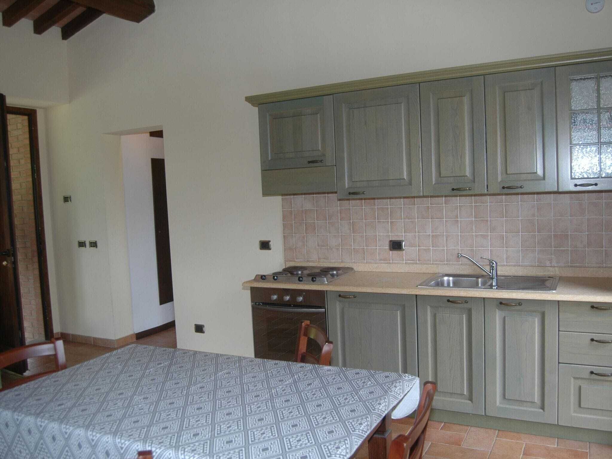A compact kitchen with a stove, sink, and cabinets.