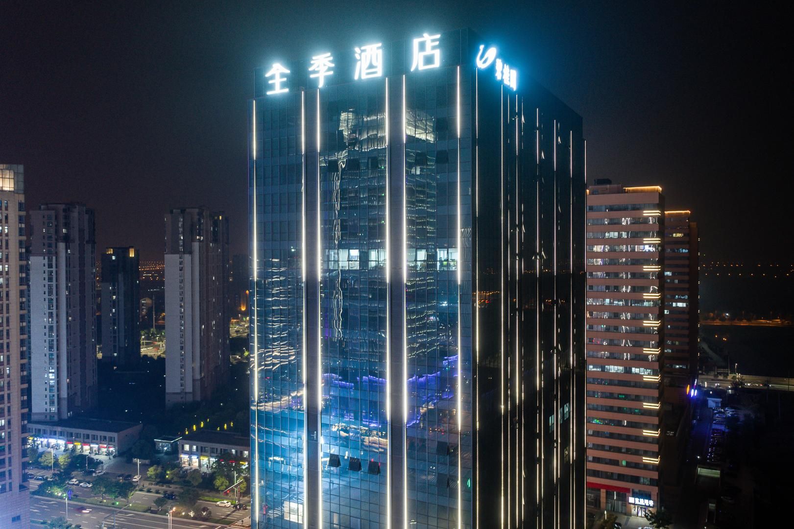 A high-rise hotel with illuminated vertical lines and signage.