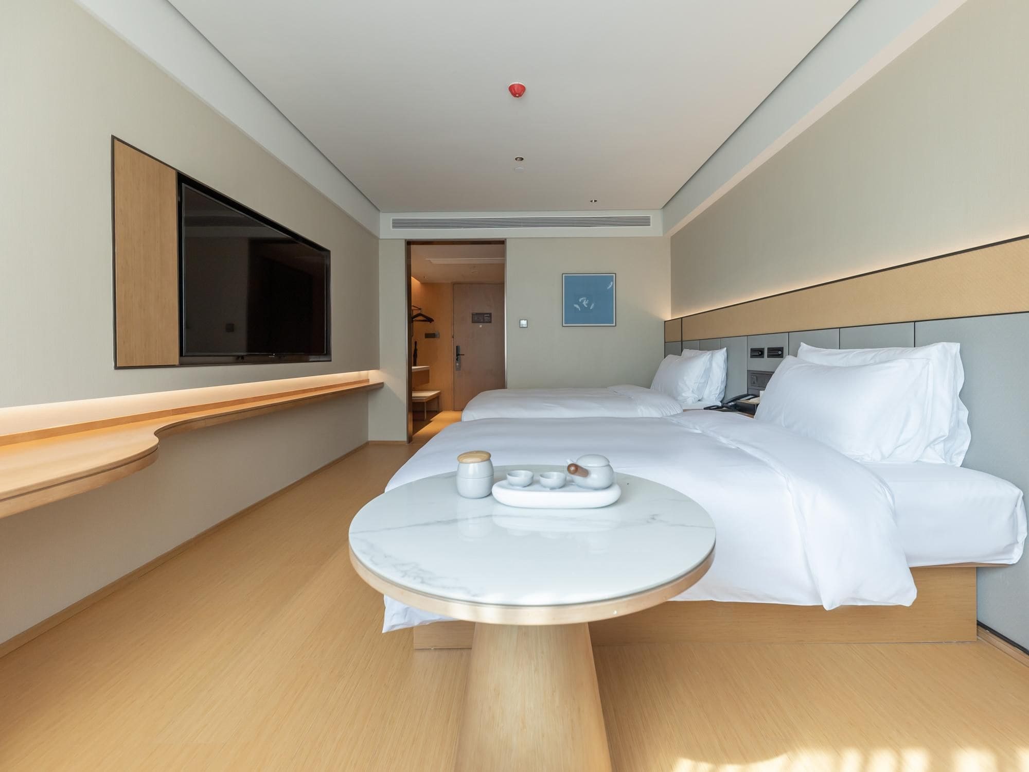 A hotel room with a bed, bedside table, and a television.