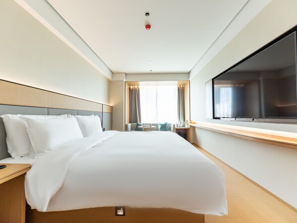 A hotel room with a bed, bedside tables, a TV, and a window with curtains. - Ji Hotel (Suzhou)