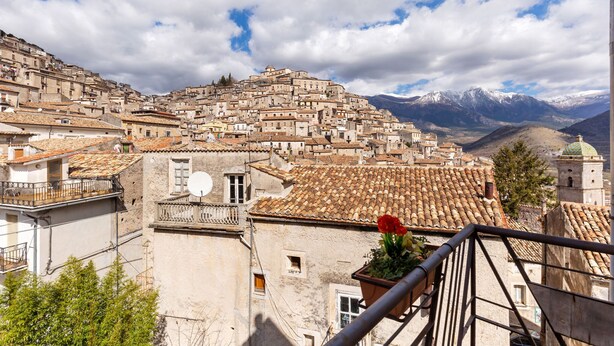Une ville pittoresque, construite à flanc de colline, avec une architecture traditionnelle et dominée par un paysage montagneux.